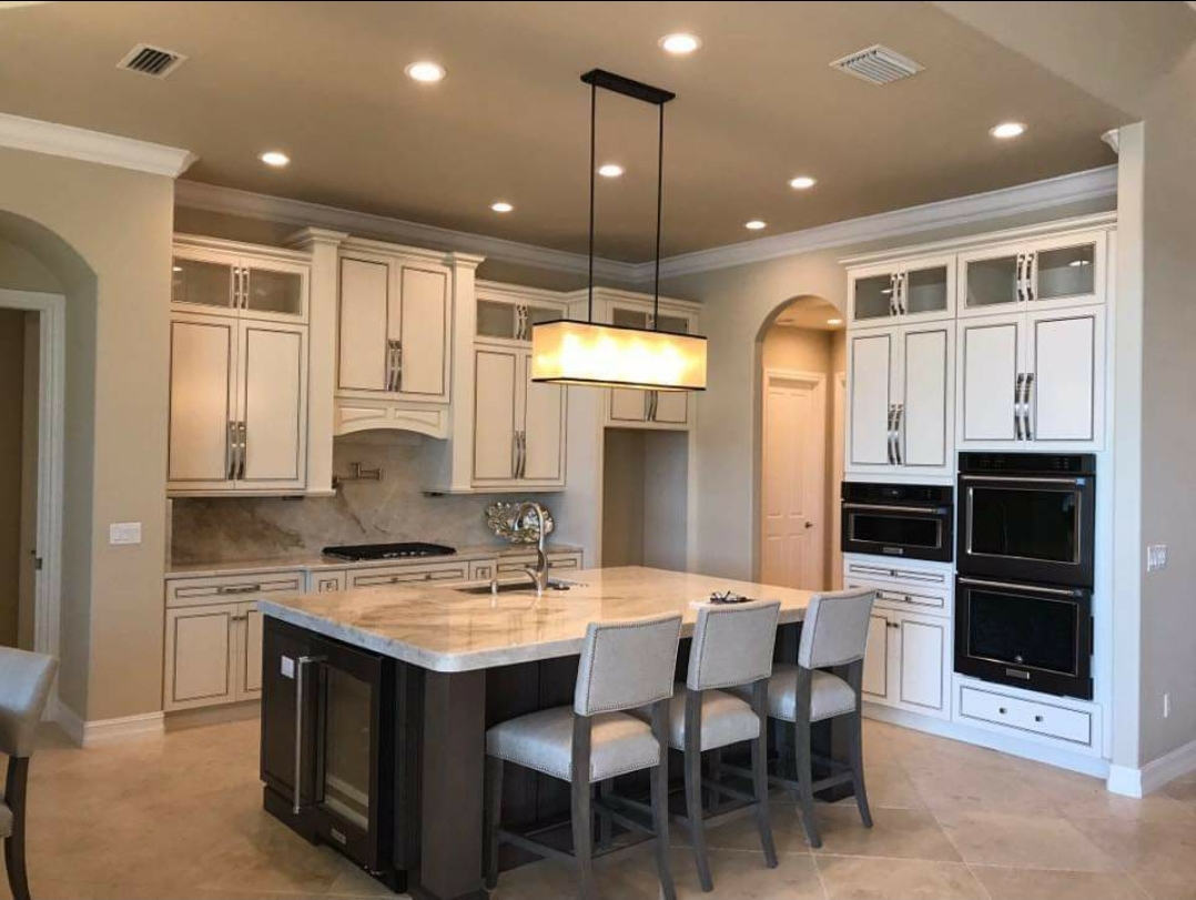 Custom new construction kitchen with marble island and pendant lighting